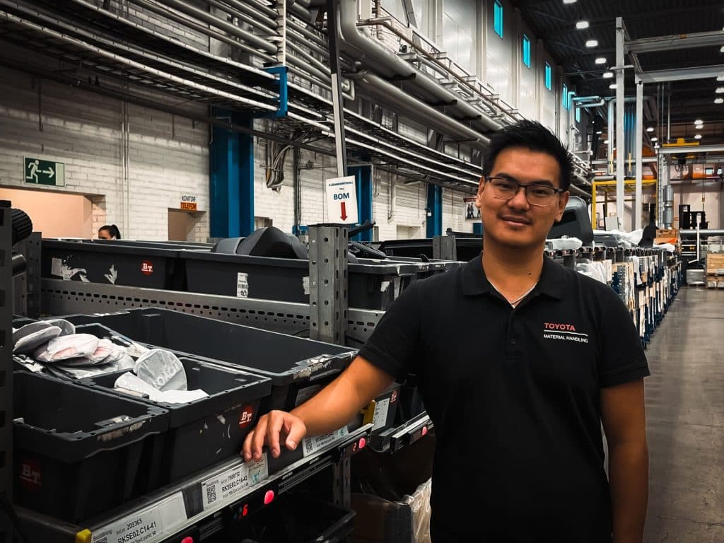 Man in stock environment next to boxes with products