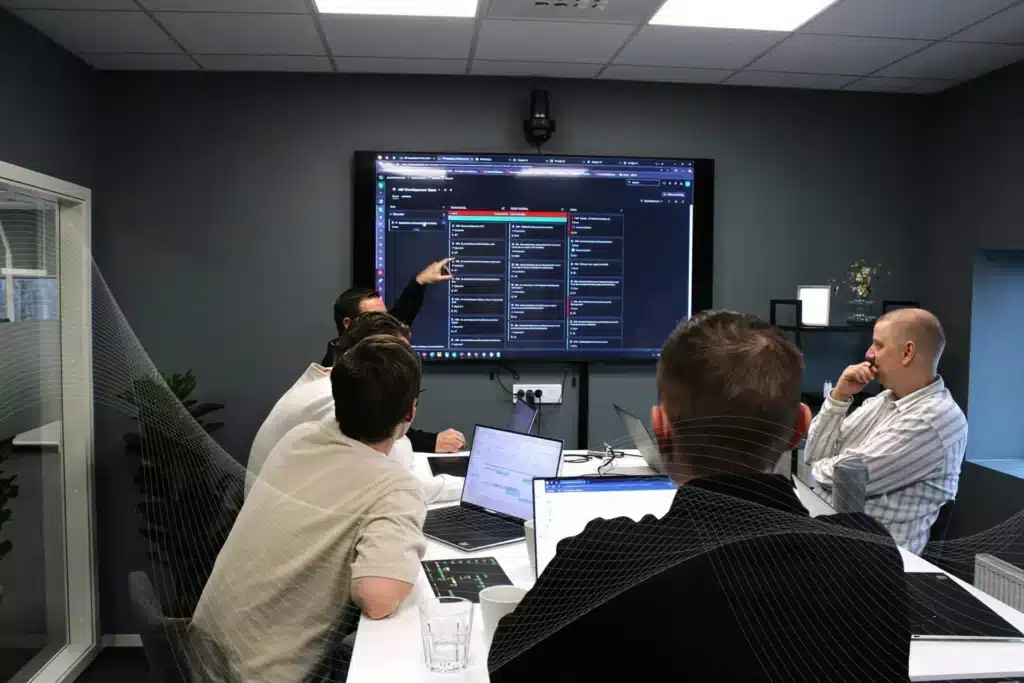 People in a conference screen looking at a screen with project details